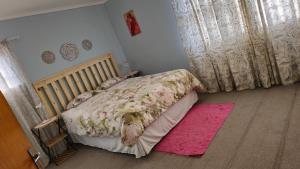 a bedroom with a bed with a pink blanket at Lindas Haven in Swakopmund
