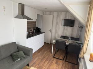 a living room with a couch and a table and a kitchen at Appartement Lefferts in Zandvoort