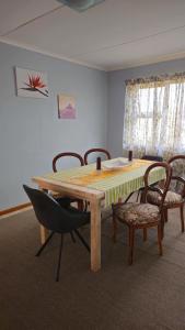 a dining room table and chairs with a yellow and white table at Lindas Haven in Swakopmund +10 photos
