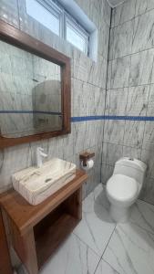 a bathroom with a toilet and a sink and a mirror at The Wave Hostel Corn Island in Corn Islands +76 photos