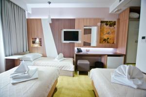 a hotel room with two beds and a desk at Hotel Herceg in Međugorje