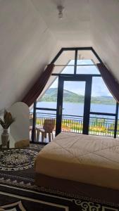 a bedroom with a bed and a view of the water at Villa Annisa 2 in Alahanpanjang