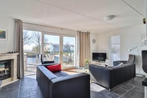 a living room with two couches and a fireplace at Villa Seaview met Sauna in Makkum +21 photos