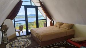 a bedroom with a bed and a large window at Villa Annisa 2 in Alahanpanjang