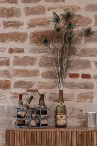 a bottle of wine and peacock feathers on a shelf at Hôtel L'Ouvrée in Savigny-lès-Beaune +28 photos