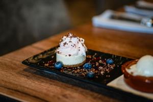a piece of cake on a black plate on a table at Hótel Valaskjálf in Egilsstaðir