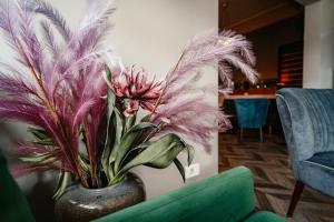 a vase filled with purple plants in a room at Hótel Valaskjálf in Egilsstaðir