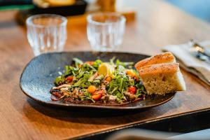 a plate of food with a salad and a piece of bread at Hótel Valaskjálf in Egilsstaðir +52 photos