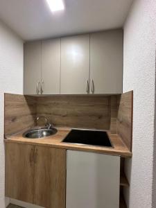 a kitchen with a sink and white cabinets at Apartments Aventra in Visoko