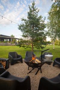 a fire pit in a yard with chairs and a tree at Laumiņas in Pavasari