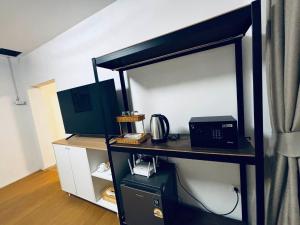 a room with a desk with a microwave and a printer at Phuket gateway inn in Kathu