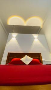 a bedroom with a red bed with two lights above it at Kanchi's please in Udawalawe +11 photos