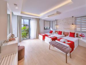 a living room with two white couches and red pillows at Lale Hotel in Kaş +76 photos