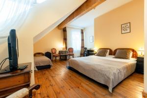 a bedroom with a bed and a flat screen tv at Marcienas Muiza & SPA in Mārciena