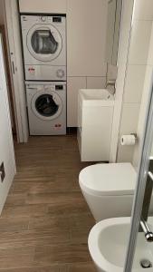 a bathroom with a toilet and a washer and dryer at La Contessa Home in Avellino