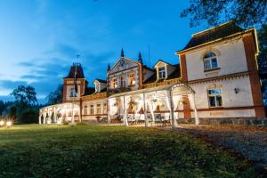 a large house with a large yard in front of it at Marcienas Muiza & SPA in Mārciena