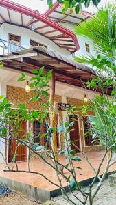 a house with a wooden porch with a roof at Kanchi's please in Udawalawe
