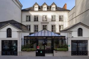 a large white building with a gate in front of it at Hotel Jean Moët in Épernay