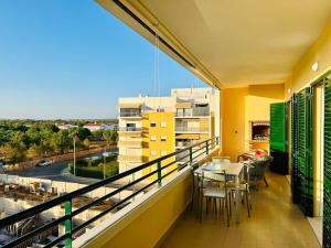 a balcony with a table and a view of a city at The Seashell Armação Beach Apartment in Armação de Pêra