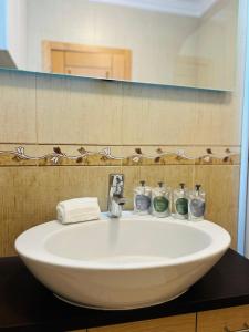 a white sink in a bathroom with a mirror at The Seashell Armação Beach Apartment in Armação de Pêra +15 photos