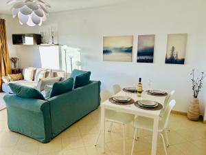 a living room with a blue couch and a table at The Seashell Armação Beach Apartment in Armação de Pêra