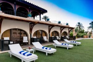 a group of lounge chairs on a lawn in front of a building at Basma Hotel Aswan in Aswan