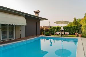 a large blue swimming pool next to a house at Villa Elisa Relax in Pozzolengo