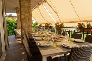 a long table with plates and wine glasses on a patio at Villa Elisa Relax in Pozzolengo