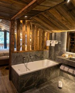 a bathroom with a large tub in a room at Hotel Vall d'Isard Suites in El Tarter