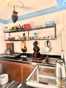 a kitchen with a stove and a sink and shelves at Binic guest house in Taghazout