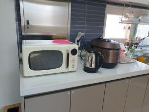 a microwave sitting on a counter in a kitchen at Stay Mokpo,2R1B,목포역,케이블카,동부시장,최대4인 in Mokpo