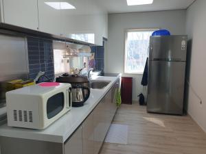 a kitchen with a microwave and a refrigerator at Stay Mokpo,2R1B,목포역,케이블카,동부시장,최대4인 in Mokpo