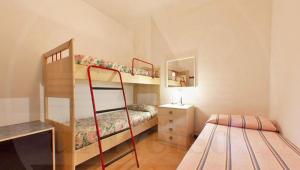 a small bedroom with two bunk beds and a desk at Bungalow Baleno in Eraclea Mare