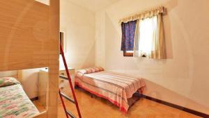 a bedroom with a bunk bed and a ladder at Bungalow Baleno in Eraclea Mare