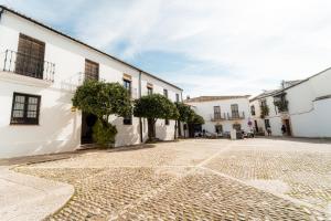 a cobblestone street in a town with white buildings at GAV Ciudad in Ronda