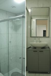 a bathroom with a glass shower and a sink at Refugio Premium 2 Quartos 1 Suite WiFi Ar e Garagem in Pelotas +12 photos