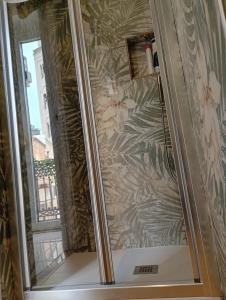 a shower with a glass door with a floral wallpaper at B&B Romeo in Bari +69 photos