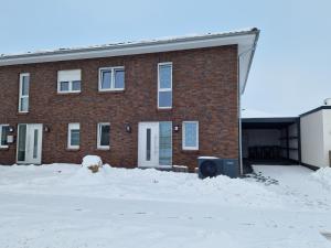 a brick building with snow in front of it at Monteurwohnung RoomWork24 - 10 Betten - Twistringen in Twistringen