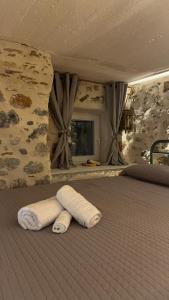 a bed with a rolled up towel on it at Sadarmis Houses in Leonidio