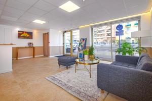 an office lobby with couches and a table and windows at Hotel Parisien in Menton +34 photos