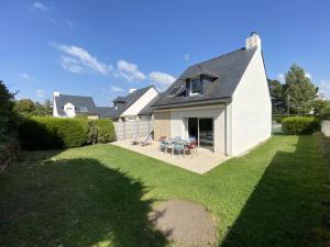 a yard with a white house with a table and chairs at RIVAGE - Villa 6 pièces, Jardin, Calme - S28 in Carnac