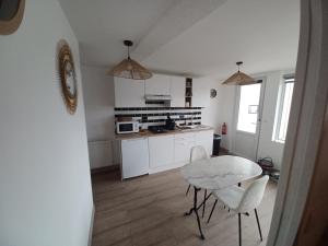 a kitchen with a table and chairs in a room at Le bon accueil in Coucy