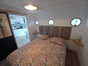 a bedroom with a bed and two mirrors on the wall at Le bon accueil in Coucy