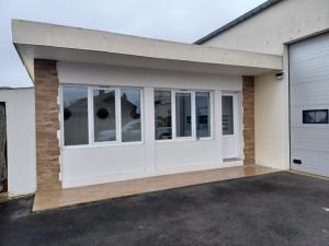 a garage with white doors on a house at Le bon accueil in Coucy
