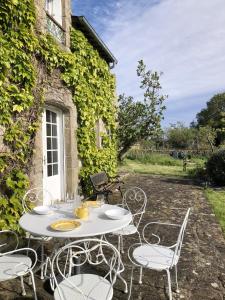 a white table and chairs in front of a building at KERDERFF - Longere entre plage et foret - TK30 in Carnac