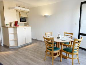 a kitchen and a dining room with a table and chairs at BLEUE OCEANE - Studio, Piscine commune - U65 in Carnac