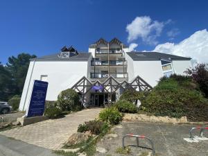a large white building with a sign in front of it at BLEUE OCEANE - Studio, Piscine commune - U65 in Carnac