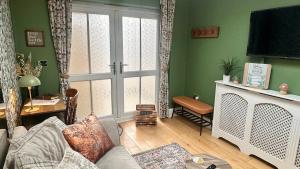 a living room with a couch and a large window at Garden Galley Nook in Sproatley