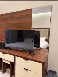 a desk with a television and a mirror at Milano Hotel in Al-ʿUla