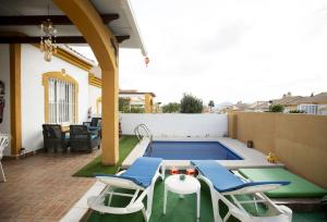 a patio with a pool and chairs and a table at Bluemoon 2 in Mazarrón
